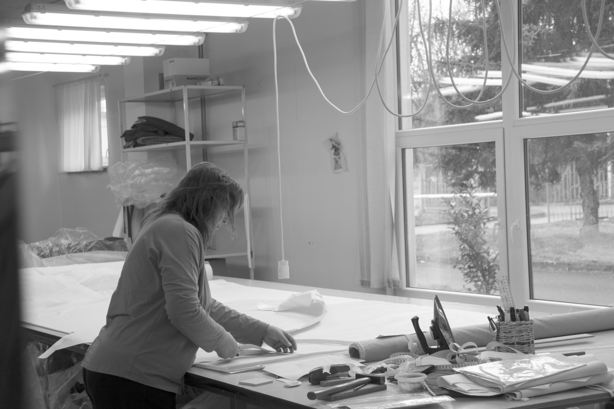Employee at the cutting table in the OSKA workshop, black and white photo