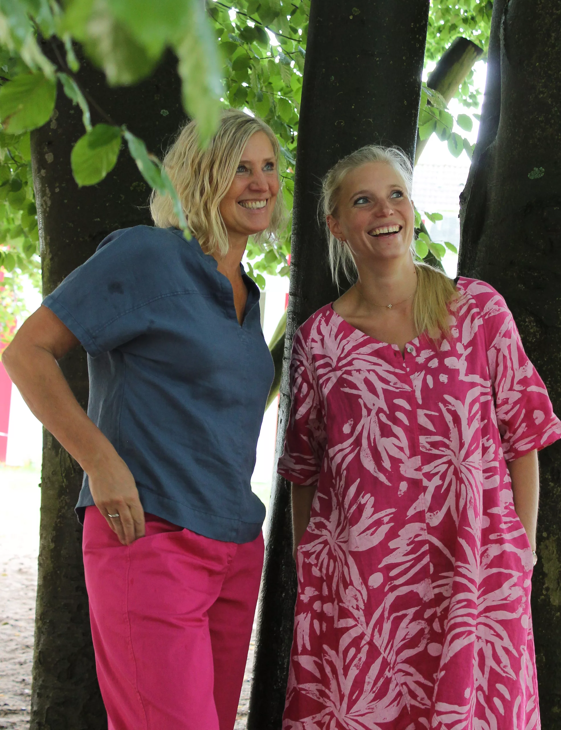 Angela und Vanessa lachen zwischen Bäumen im Kindergartengarten