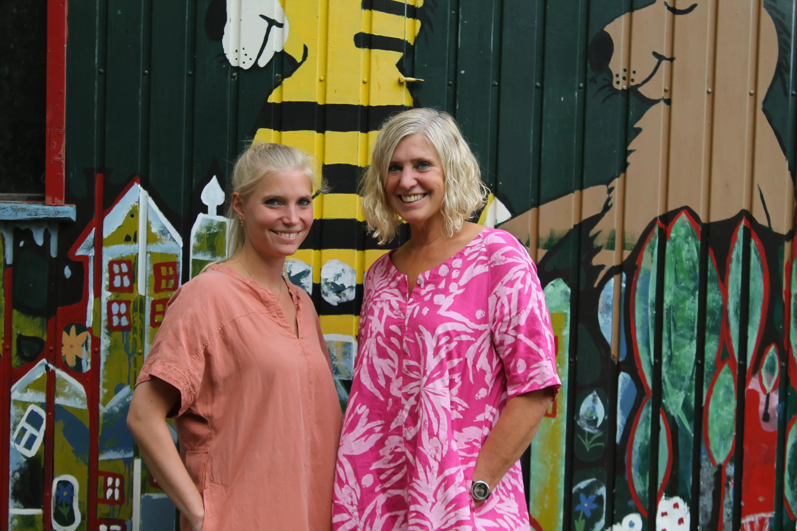 Angela und Vanessa vor einer bunt bemalten Wand