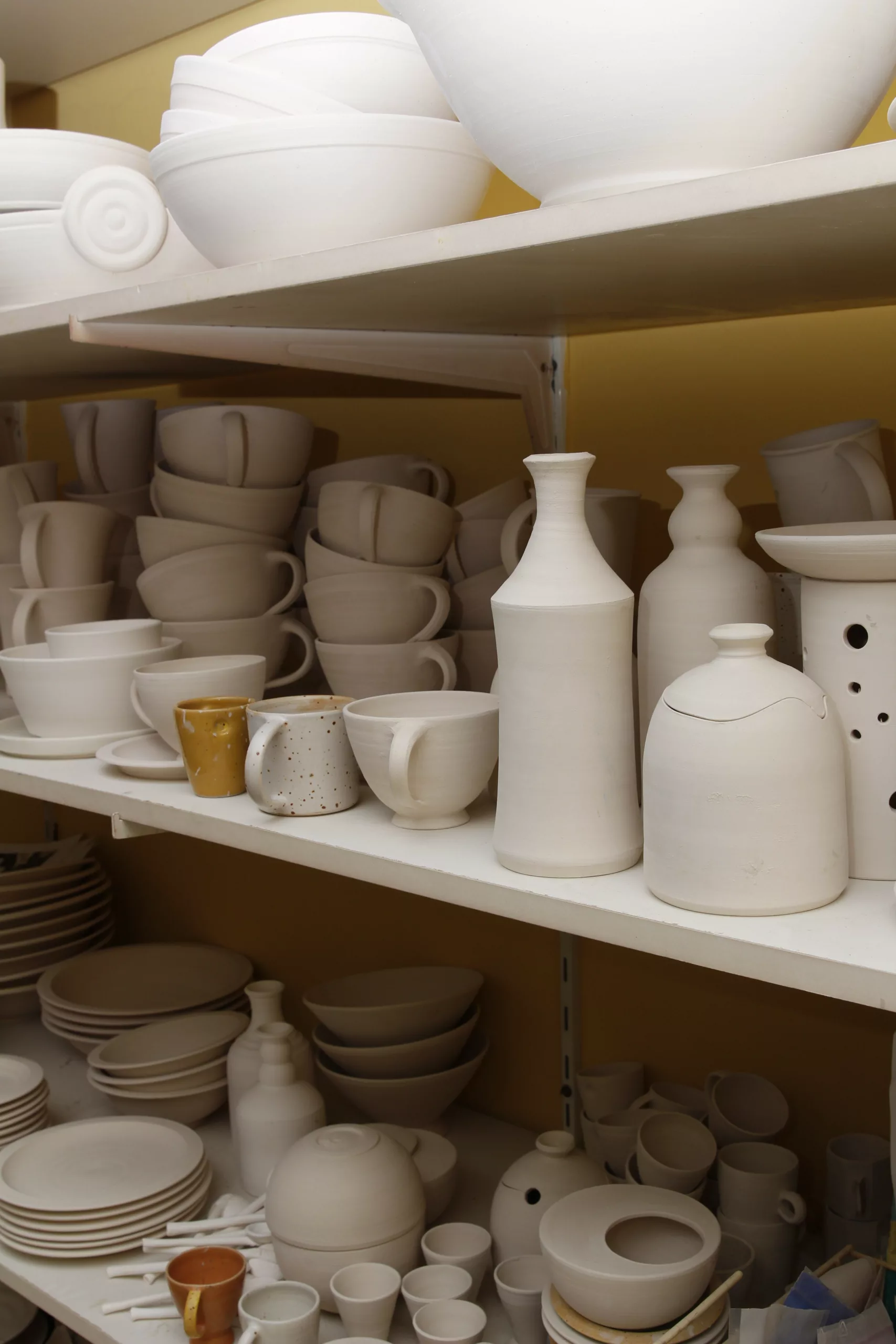 Shelves full of white ceramics: cups, bowls, vases and plates