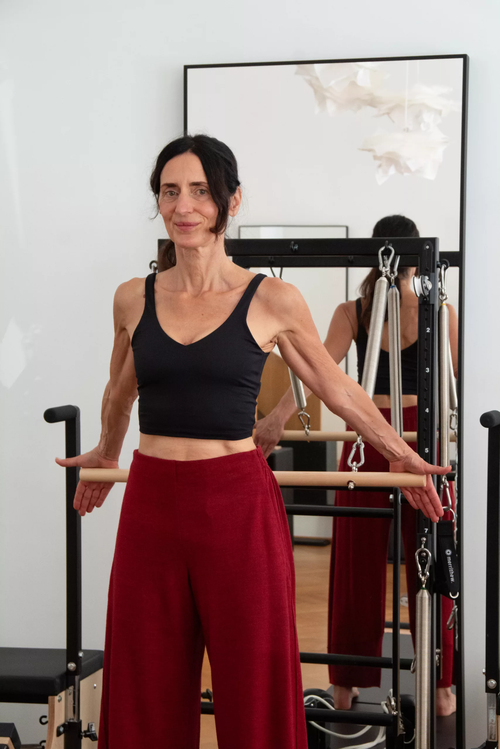 Iris in schwarzem Top und roter Hose in ihrem Studio
