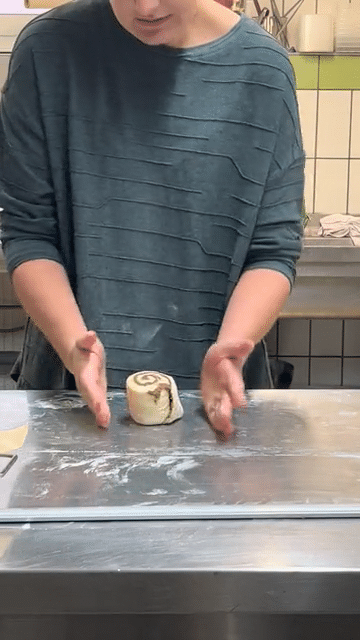 Hände formen eine Zimtschnecke
