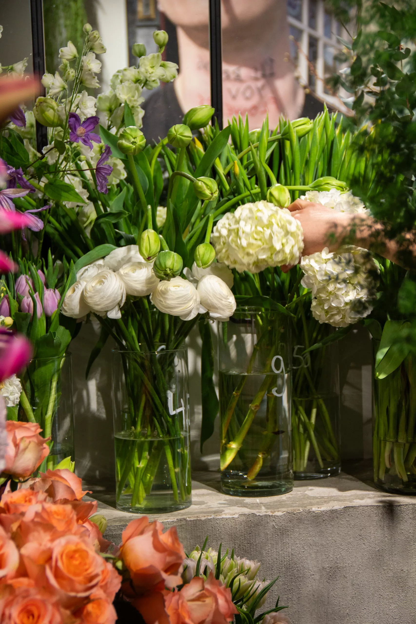 Ranunkeln, Hortensien und Rosen in Vasen im Blumenladen