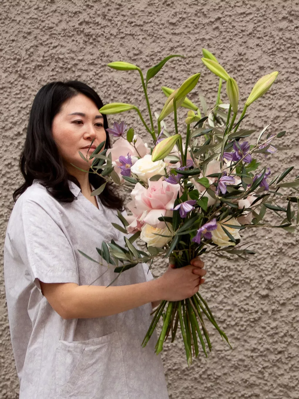 Ji mit einem großen Strauß aus Rosen, Lilien und Olivenzweigen