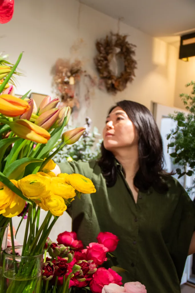 Ji zwischen Tulpen und Ranunkeln in ihrem Laden
