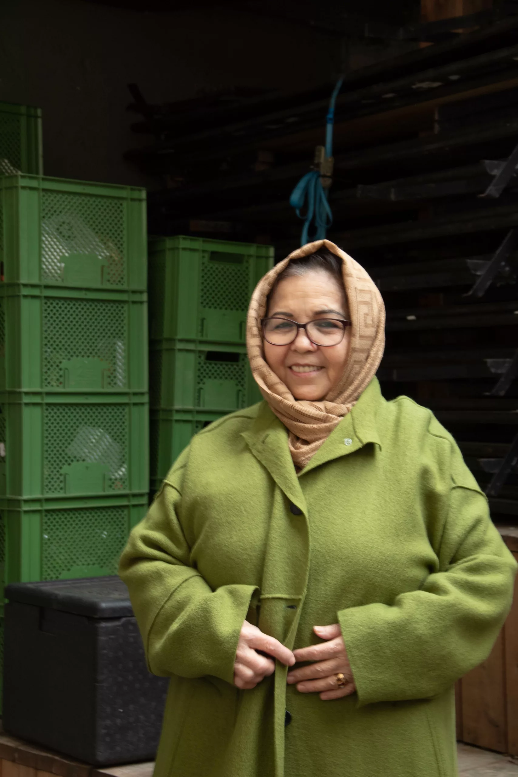 Woman with a beige headscarf and green wool coat