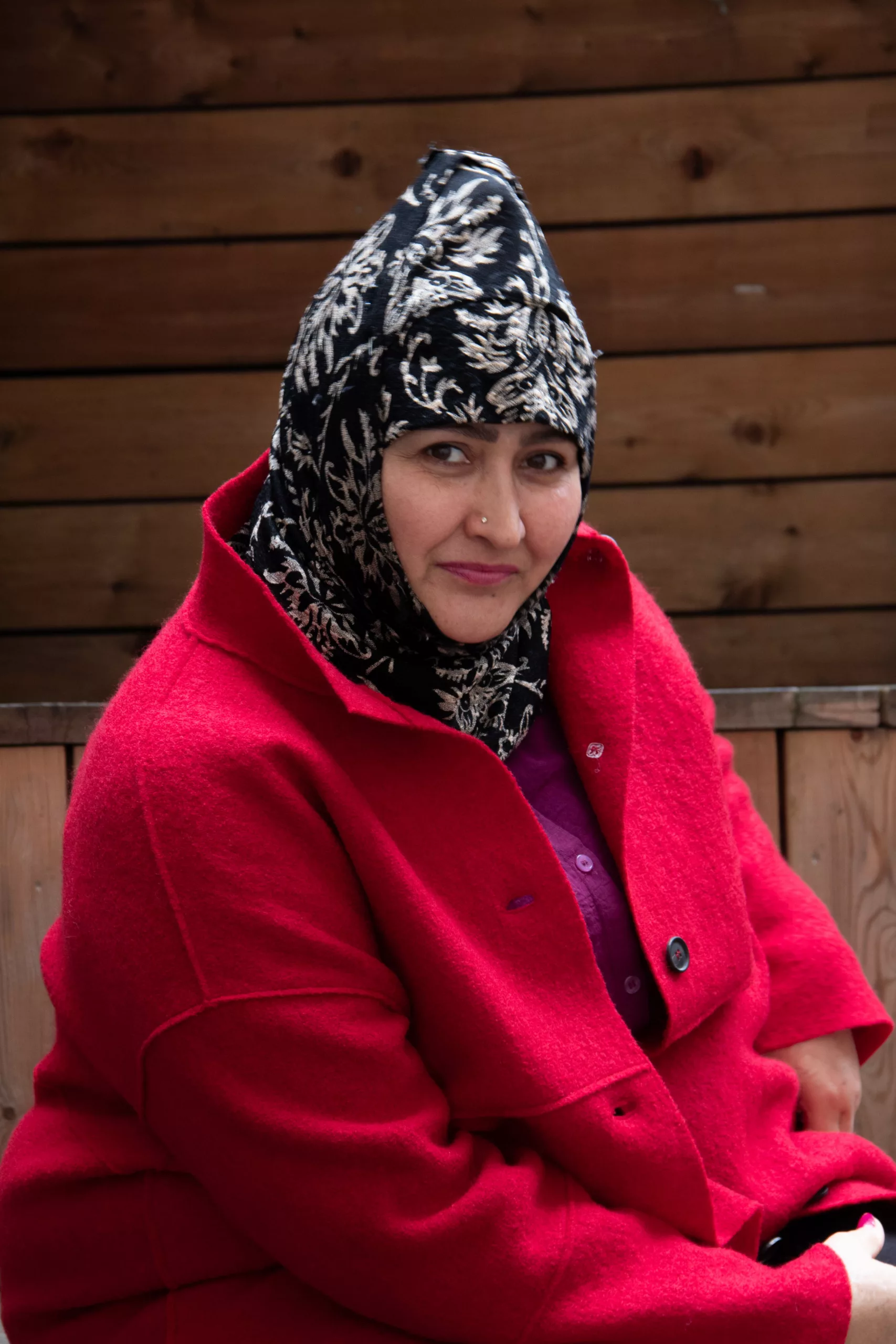 Woman with a patterned headscarf and red coat