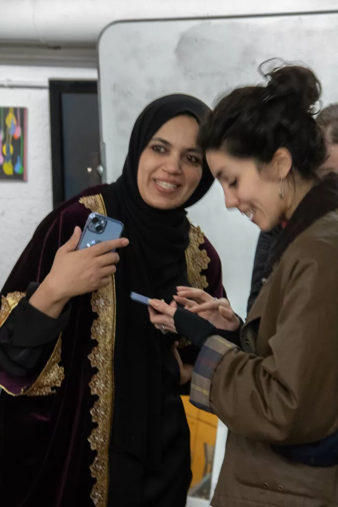 Two women laughing as they look at a phone