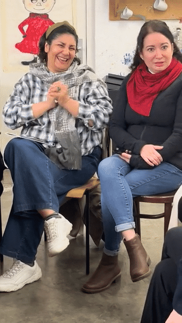 Two women laughing on their chairs