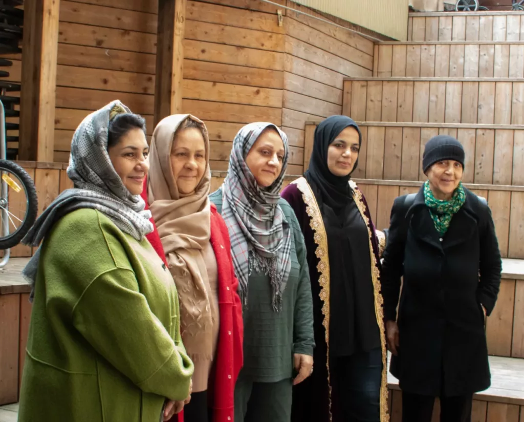 Five women in coats on wooden steps