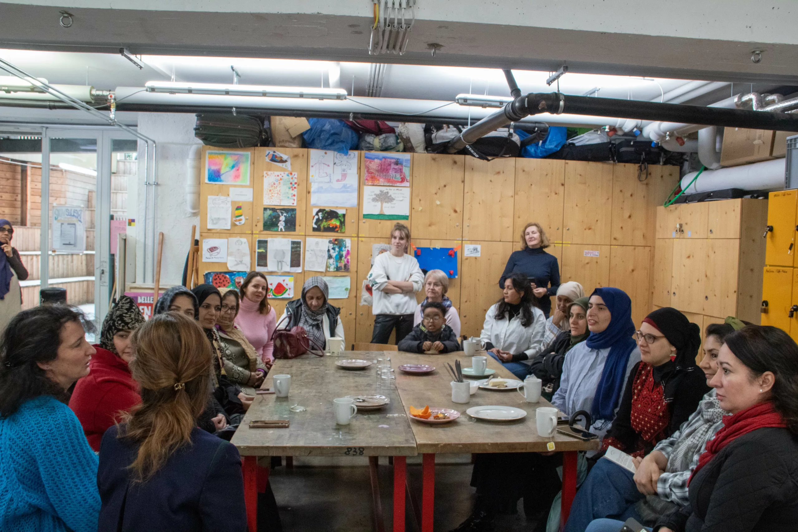 Many women sitting at a long table in the women's café