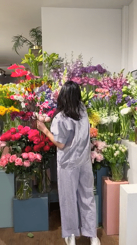 Ji vor einer bunten Blumenauslage