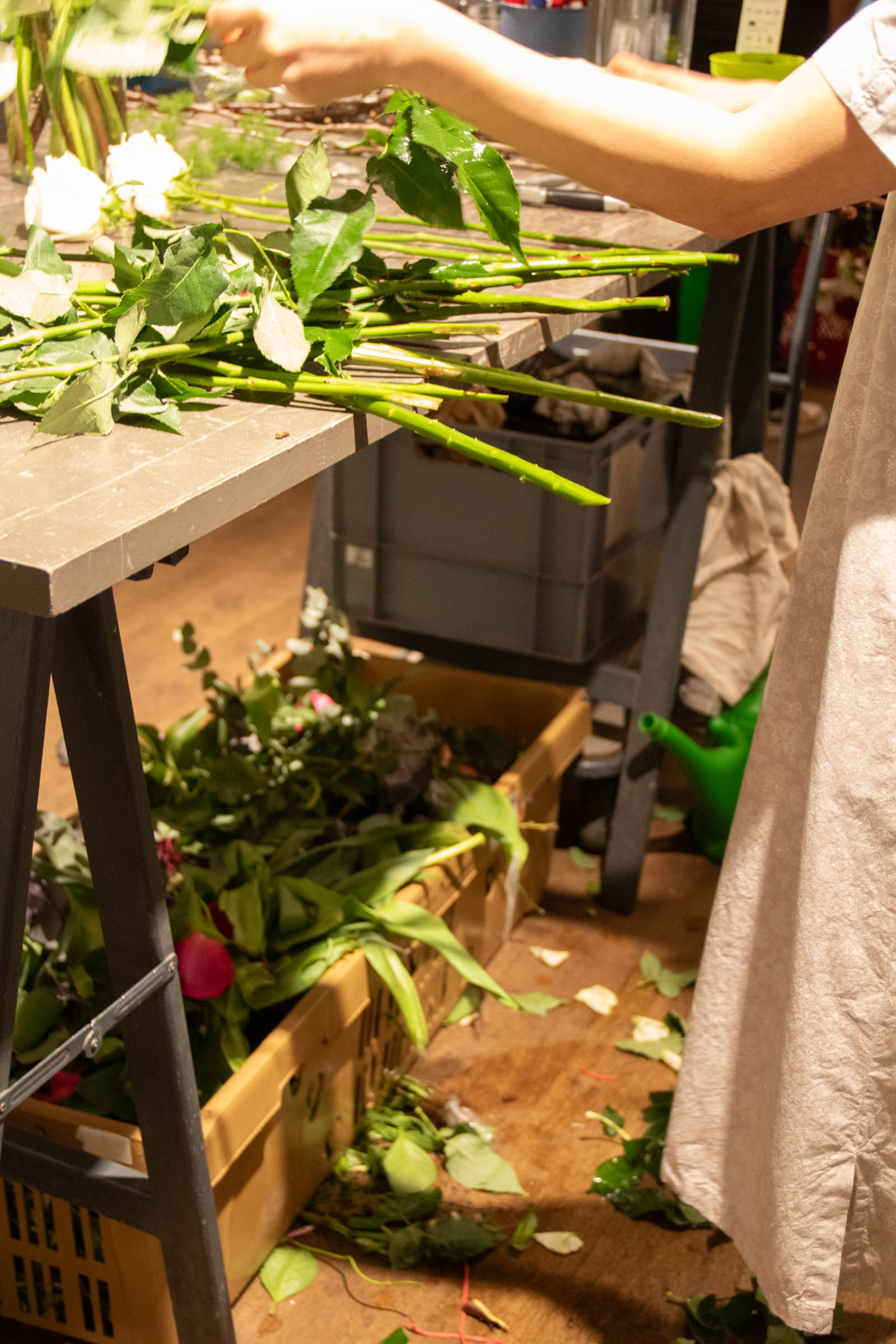 Weiße Rosen werden am Werktisch vorbereitet