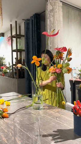 Ji stellt Blumen in eine Glasvase