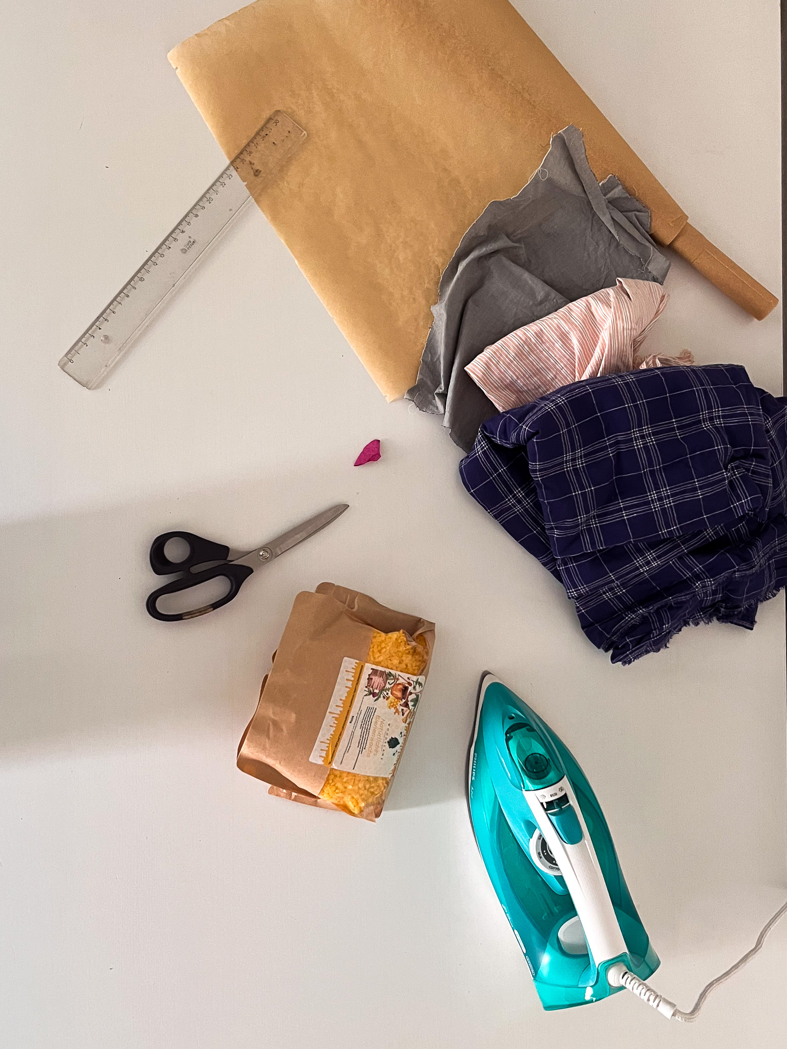 Material für Wachstücher: Stoffreste, Backpapier, Lineal, Schere, Bienenwachs und Bügeleisen