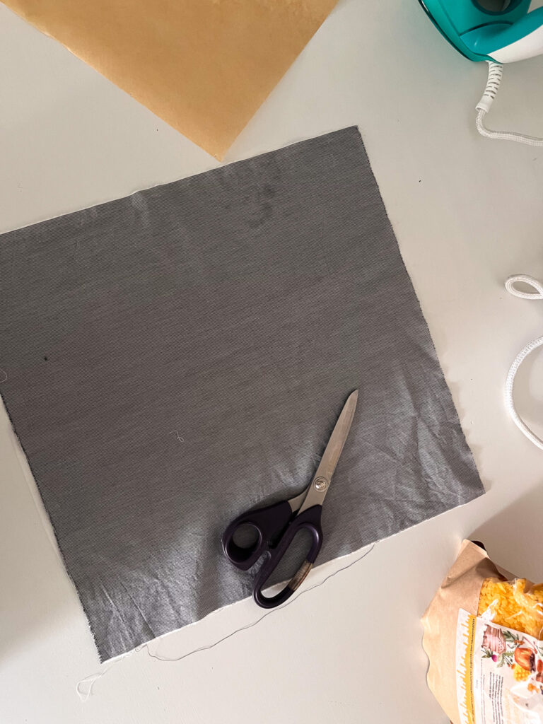 Grauer Baumwollstoff mit Schere