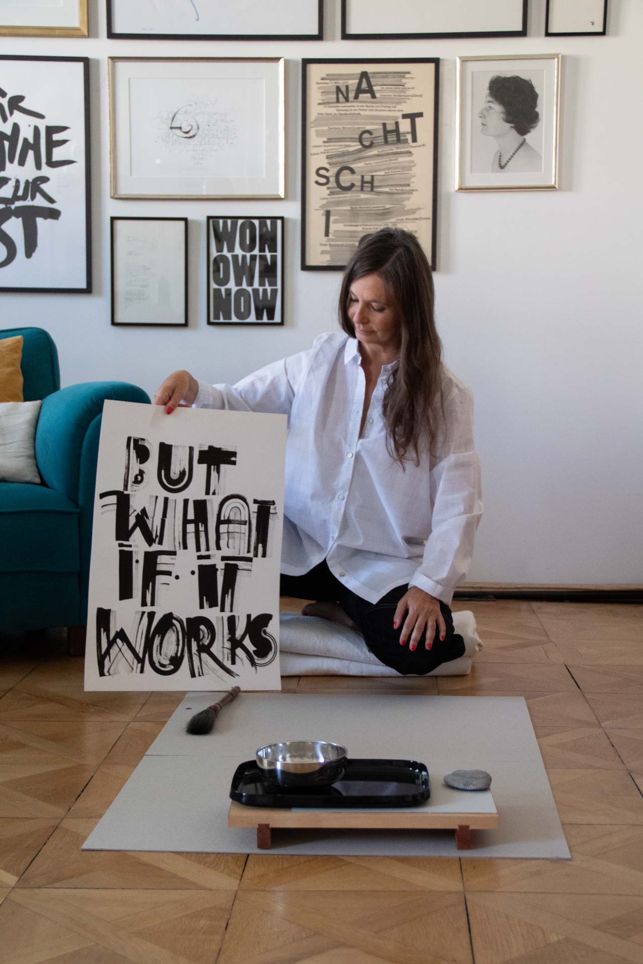 Petra kniet neben ihrem Plakat But what if it works
