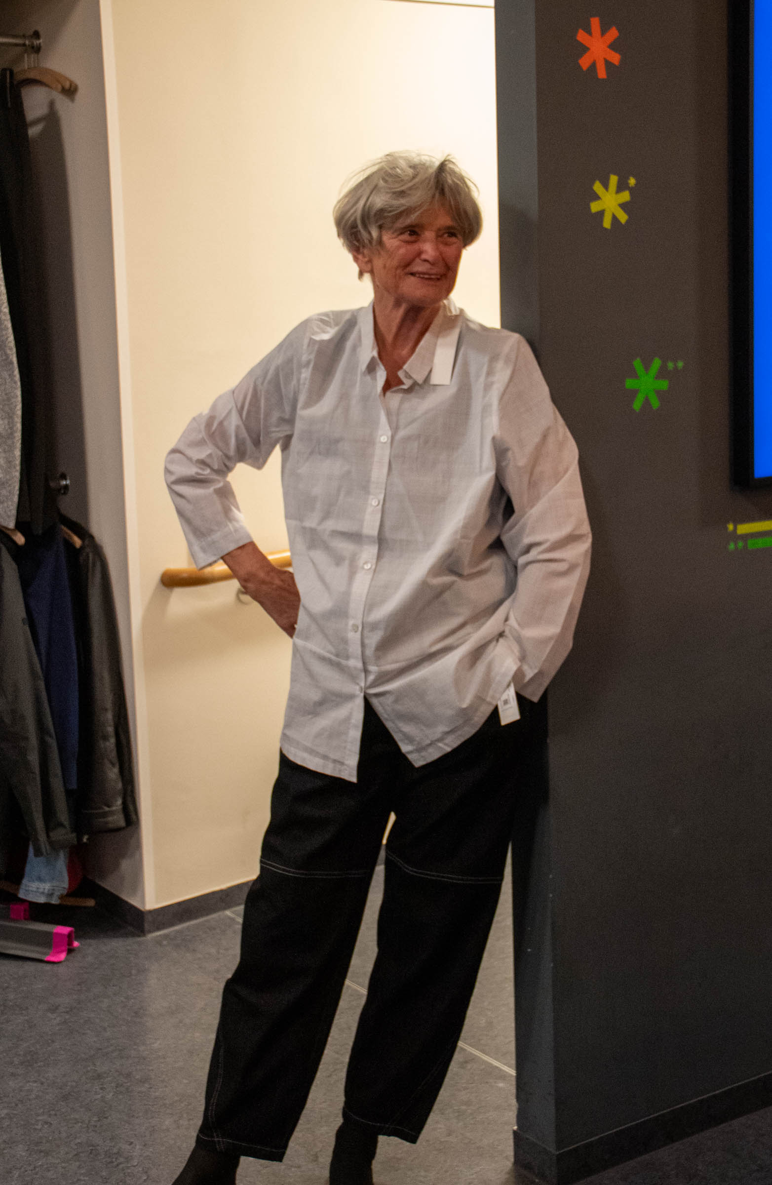 Frau in weißer Bluse lehnt an der Wand