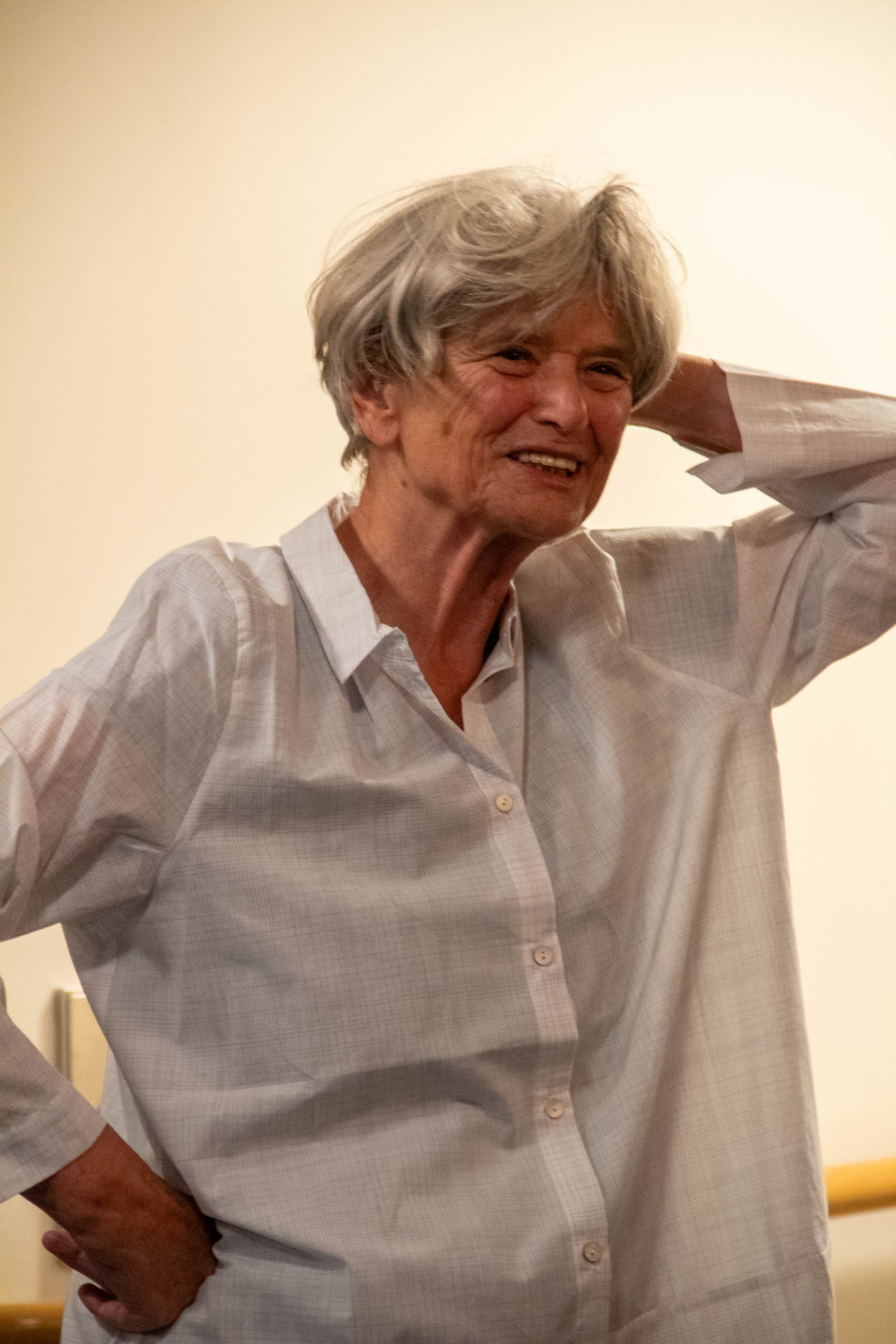 Frau mit grauen Haaren in weißer Bluse