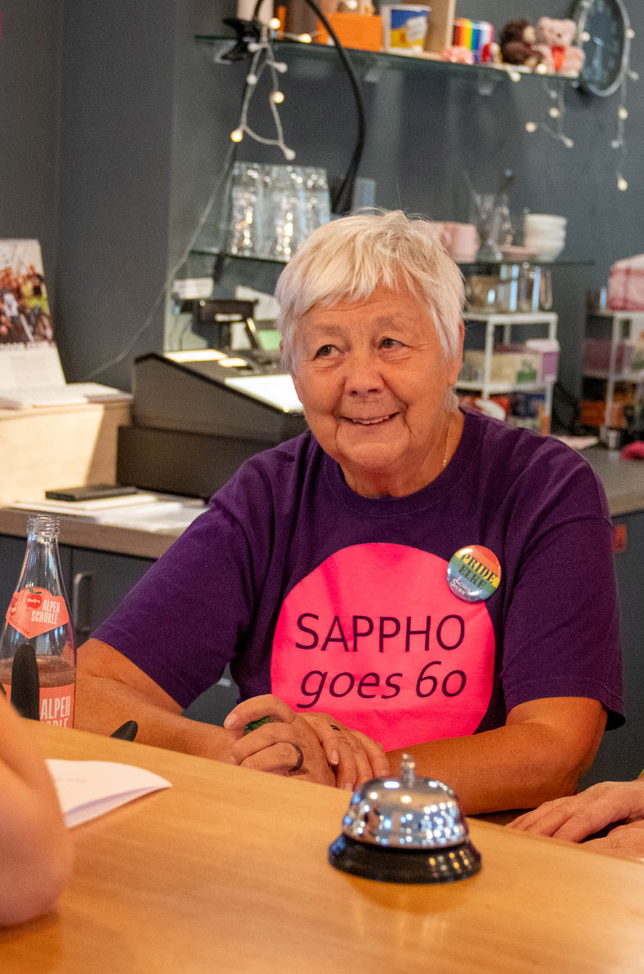 Frau im T-Shirt Sappho goes 60 am Tresen